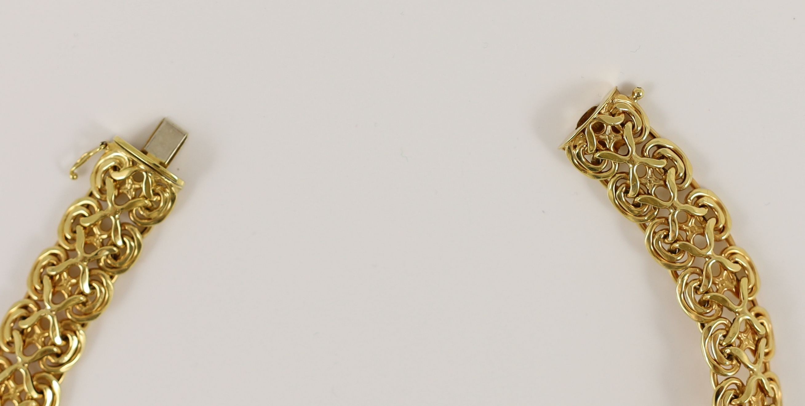 A modern 14k gold pierced scroll link necklace